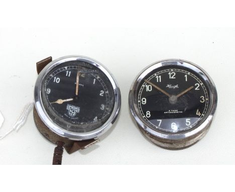 A Smiths 8-day dashboard clock, the black dial with Arabic numerals, 6cms (2.5ins) diameter; together with a rim wind example