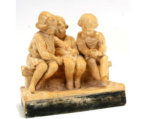 An early 20th century plaster group depicting three children seated on a bench, 30cms (12ins) wide.(a/f)