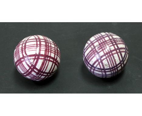 A pair of 19th century Scottish pottery carpet bowls with purple plaid decoration, 7.5cms (3ins) diameter (2).