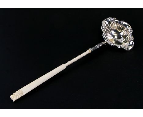 A large long ivory handled un-hallmarked silver toddy ladle, 45cms (17.75ins) long.