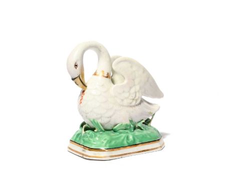 A rare Chamberlain's Worcester figure of the Pelican in her Piety, c.1810-20, the bird modelled with wings raised behind, her