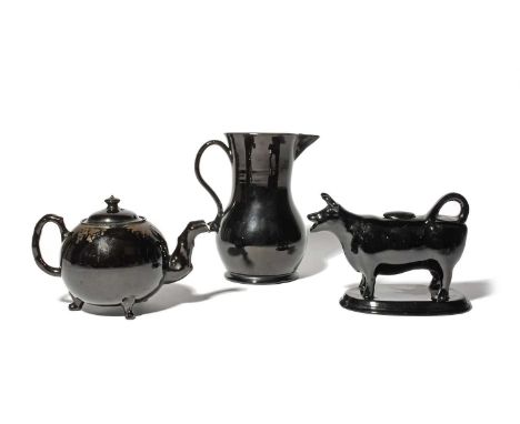 A large Jackfield jug and a teapot and cover, c.1760-80, the teapot with crabstock spout and handle, raised on three paw feet