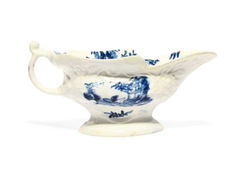 A Worcester blue and white sauceboat, c.1755, painted with the Sinking Boat Fisherman pattern, within rococo moulded panels, 