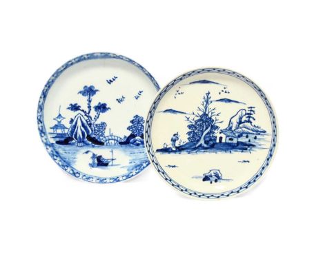 Two Vauxhall blue and white saucers, c.1755-57, one painted with a boat before an arched bridge linking rocky islands, the ot