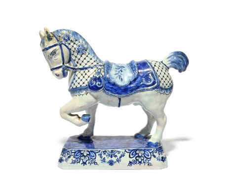 A Delft figure of a horse, late 18th century, modelled with ears pricked and left fore hoof raised, wearing a patterned saddl