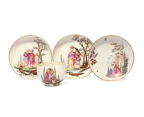 A Höchst cup and two saucers, c.1780, well painted with scenes of peasants beneath fruiting trees, the cup with a barefoot ma