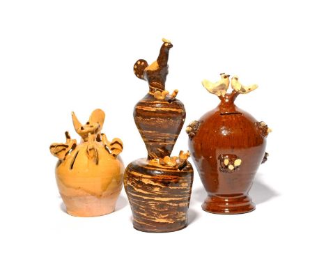 Three slipware money boxes, 19th century, one probably Yorkshire, decorated in cream slip and mounted with a chicken surround