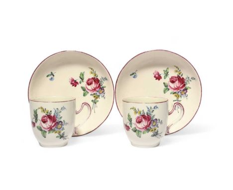 A pair of Tournai coffee cups and saucers, c.1760-70, painted with sprays of flowers including rose and forget-me-not, the sc