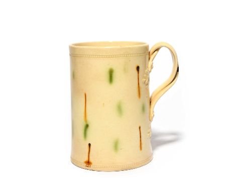 A creamware mug, c.1780, of Whieldon type, the cylindrical form decorated with small drips of green and manganese, the handle