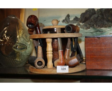 A PIPE RACK CONTAINING A QUANTITY OF VINTAGE PIPES 