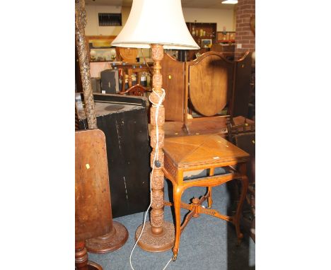 A HEAVILY CARVED ORIENTAL STYLE STANDARD LAMP