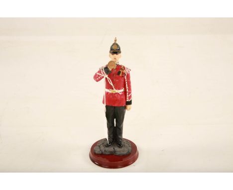 A painted composition figure of a Queen's Royal Surrey Regiment solding playing the bugle; standing on wooden plinth base; 23