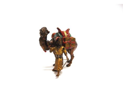 AN AUSTRIAN COLD PAINTED BRONZE  in the manner of Franz Bergman, modelled as a camel laden with packages being led by a youth
