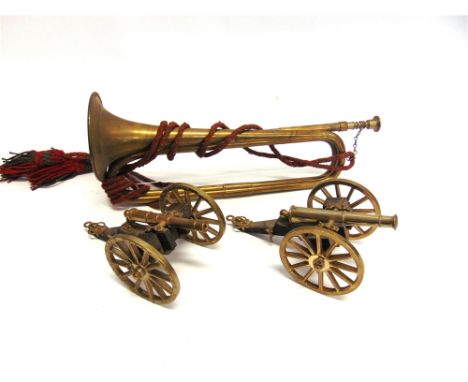 TWO MODEL FIELD GUNS  of brass and wood construction, each 20cm long; together with a brass bugle, (3).