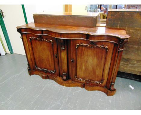 A VICTORIAN MAHOGANY CHIFFONIER  with shaped front and carved decoration, the pair of doors enclosing a single shelf, height 