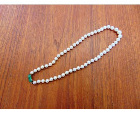 A GRADUATED ROW OF CULTURED PEARLS the fifty four pearls of approximately 6-9mm in diameter, to a carved and pierced jade pan