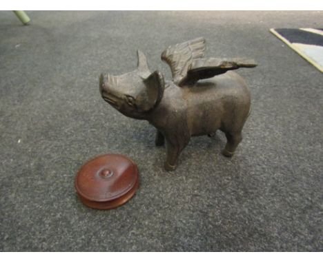 A cast iron flying pig figure and a turned wood trinket pot