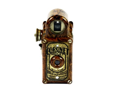 A brown marbled Bakelite coronet midget camera.