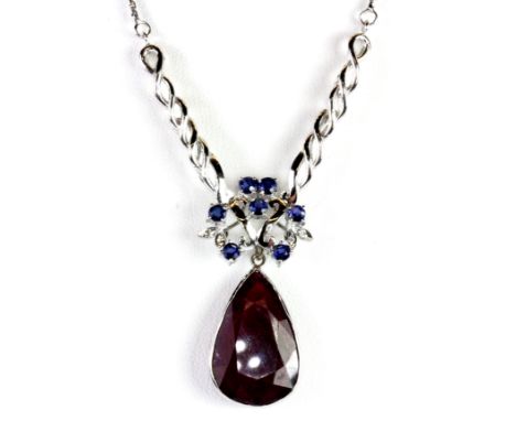 A 14ct white gold (stamped 585) necklace set with a large pear shaped ruby (L. 2.2cm) and brilliant cut sapphires and diamond
