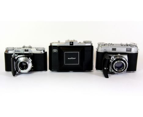 Three vintage cameras including a Zeiss icon, a Kodak folding camera with Schneider lens and a Voigtlander Vito II.