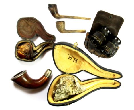 A vintage tin containing a quantity of tobacco pipes etc.