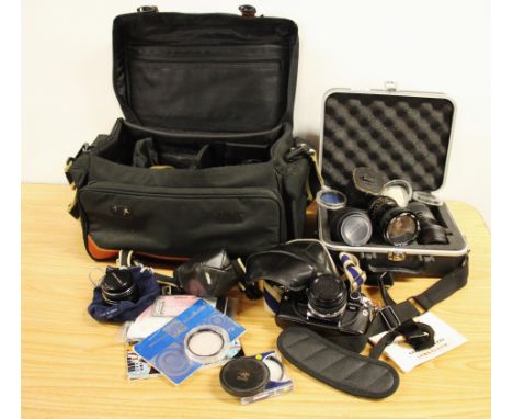 Two Pentax single lense reflex cameras with an Olympus camera and a quantity of lenses.