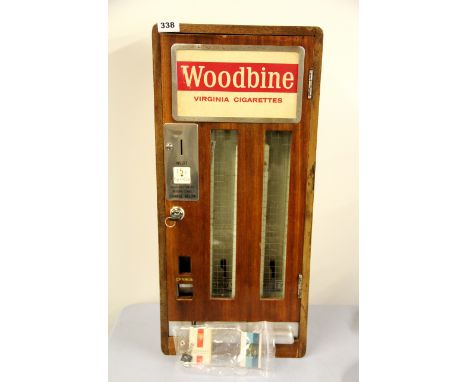 A vintage wooden cigarette machine with later lock, H. 67cms.