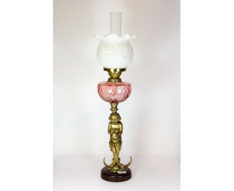 A gilt metal figural oil lamp with milk glass shade, H. 75cm.