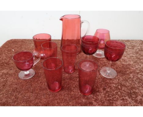 Four cranberry beakers, pair of ruby tinted stemmed wine glasses and a small selection of other cranberry glassware including