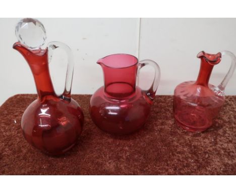 19th C cranberry jug with clear stopper and clear rope twist handle, and one other ruby glass jug 
