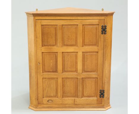 DEREK SLATER OF CRAYKEA FISHMAN OAK HANGING CORNER CUPBOARD, CIRCA 1970, the nine panel door opening to reveal three shelves,