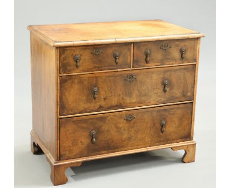 A SMALL FEATHER BANDED AND CROSSBANDED WALNUT CHEST OF DRAWERS, the moulded rectangular top above two short over two long dra