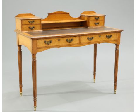 AN EDWARDIAN GOLDEN OAK WRITING DESK, the superstructure with two pairs of drawers and shelf above an inset writing surface o