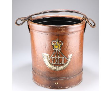 A LEATHER COVERED WASTEPAPER BIN bearing a post 1952 image of the badge of the Durham Light Infantry. 31.5cm highThe absence 
