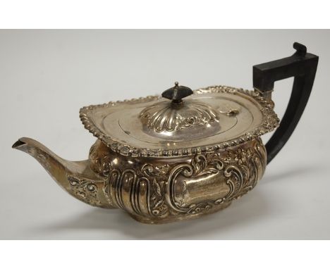 A late Victorian silver teapot of oval baluster form with reeded and leaf and flower chased decoration, engraved cartouche, g