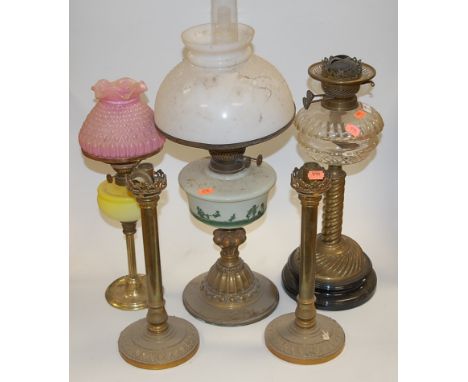 A Victorian oil lamp having opalescent glass shade above a milk glass font decorated with children at play on a brass pedesta