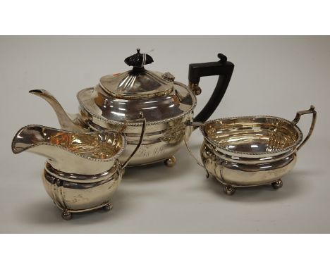 A George V bachelor's silver three piece teaset comprising teapot, twin handled sugar and cream, the teapot with presentation