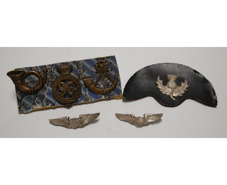 A Glengarry badge; together with a Light Infantry badge; and American wing badges etc