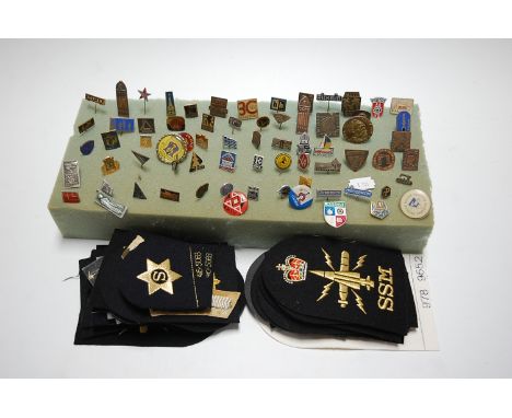 A collection of assorted mainly Eastern European lapel badges and stick pins etc; together with various cloth insignia