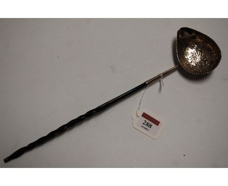 A George III silver toddy ladle, the bowl repoussee decorated with flowers having a vacant cartouche within raised beaded bor