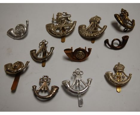 A collection of Buglers/Light Infantry cap badges and metal insignia (11)