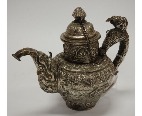 An eastern white metal and embossed teapot and cover with dragon handle, unmarked and untested, height 19cm