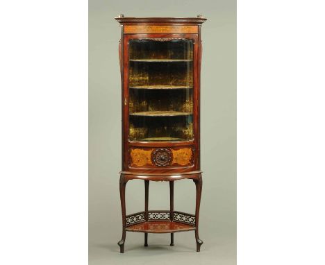 An Edwardian inlaid mahogany bowfronted standing corner cabinet, with dentil cornice above a foliate scroll carved satinwood 