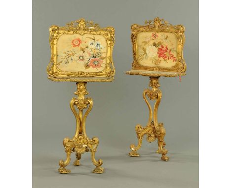 A pair of giltwood and gesso screens, with woolwork floral tapestries, with shelf to front and raised on a Rococo support, on