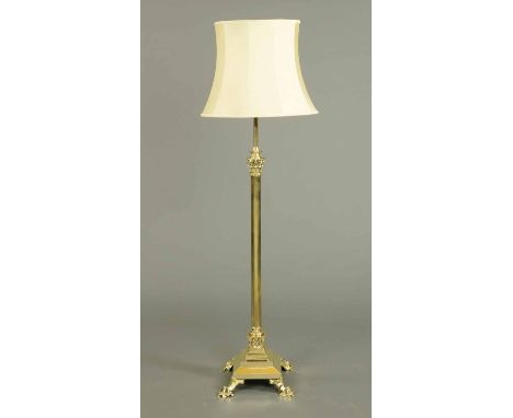 A Victorian brass lamp standard, with Corinthian capital and fluted column raised on four short legs (see illustration).  