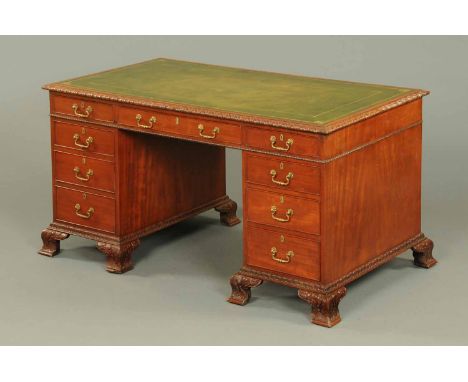 An Edwardian mahogany Chippendale style desk, with green gilt tooled leather writing surface and carved edge above three frie