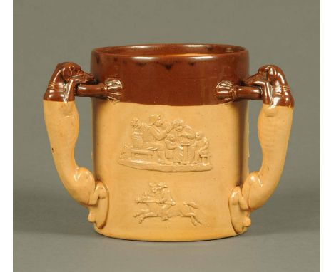 A Royal Doulton stoneware three handled loving cup, decorated with hunting and tavern scenes and with greyhound handles, impr