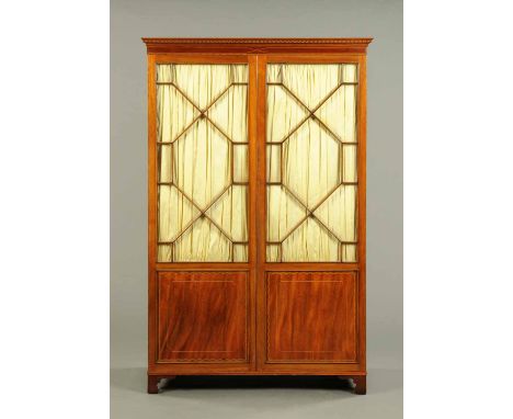 An Edwardian inlaid mahogany wardrobe, in the George III style, having a moulded cornice with boxwood strung frieze above a p