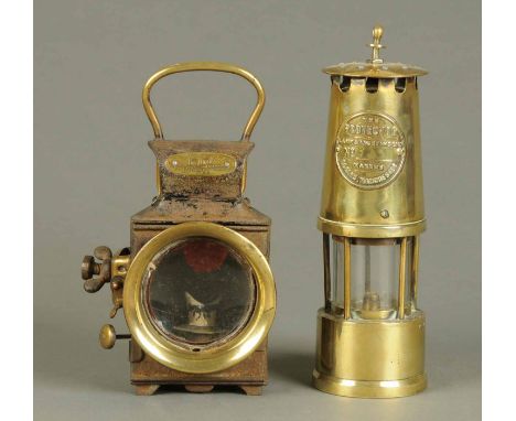 An Eccles brass miners lamp, and a railway lamp by Powell & Hammer.  Each height 11 ins. 