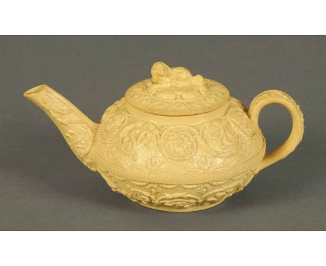 A 19th century Wedgwood salt glazed teapot, with dog terminal to lid and foliate and scroll moulded body, impressed "Wedgwood